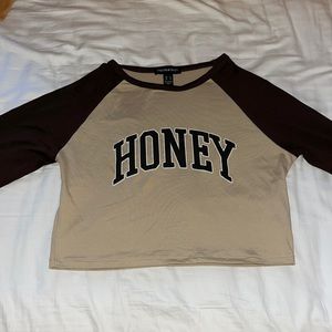 Size L but fits size XS, tan/brown, “Honey” text, long sleeve crop top.